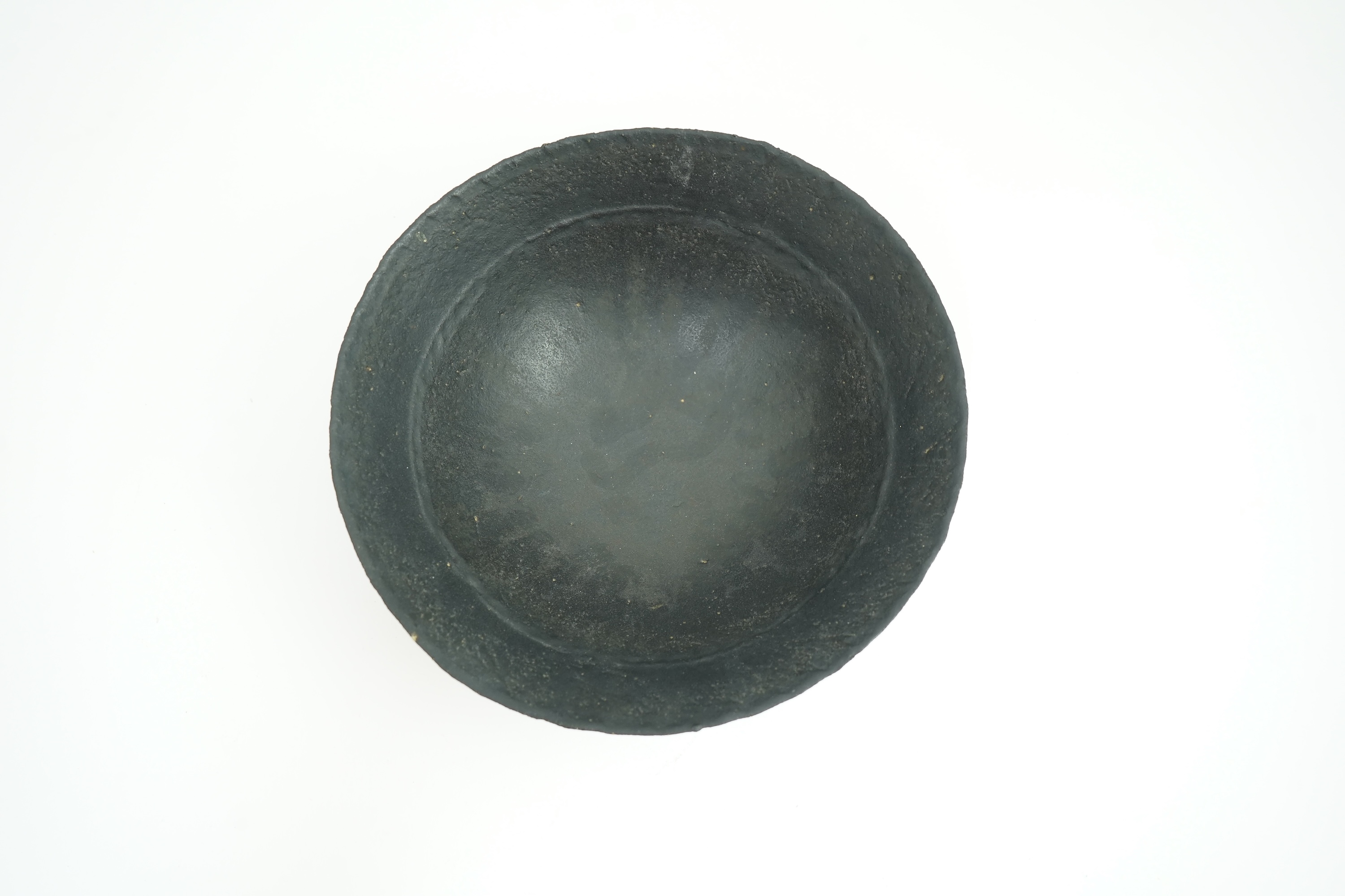 John Ward (1938-2023): A hand-built stoneware black glazed bowl with irregular rim